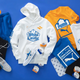 White Castle + PUMA collaboration: blue and black shorts, sneakers, white hoodie sweatshirt, yellow, blue, and white t-shirts